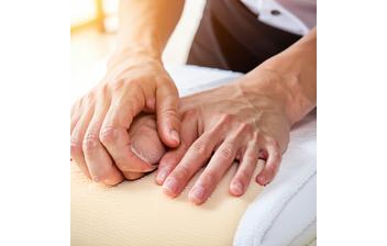 Mains expertes de nos masseurs à l'œuvre — ambiance douce, lumière naturelle